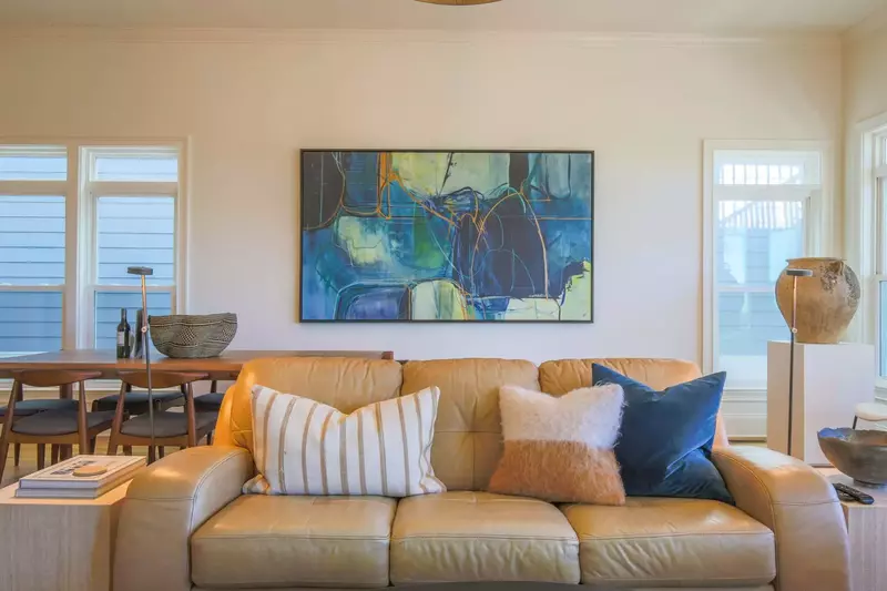 The living room features a comfortable seating area and lovely natural light from the room's many windows.