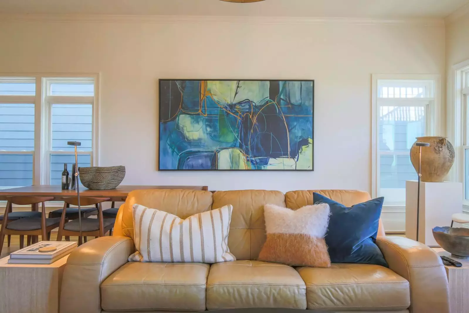 The living room features a comfortable seating area and lovely natural light from the room's many windows.