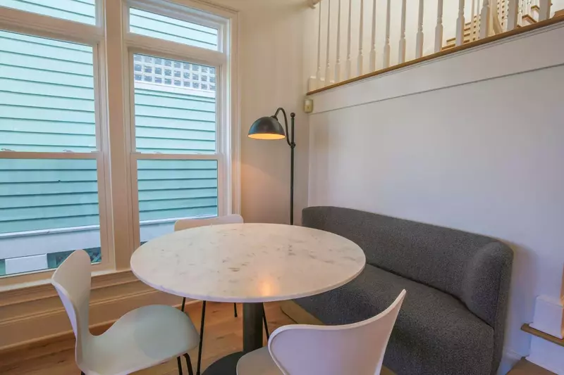 There's a game table with banquette seating in the living room near the stairwell to the second floor.