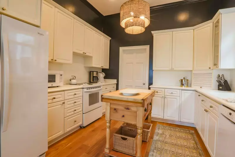 The kitchen features white cabinetry & appliances and plenty of room to prepare your meals.