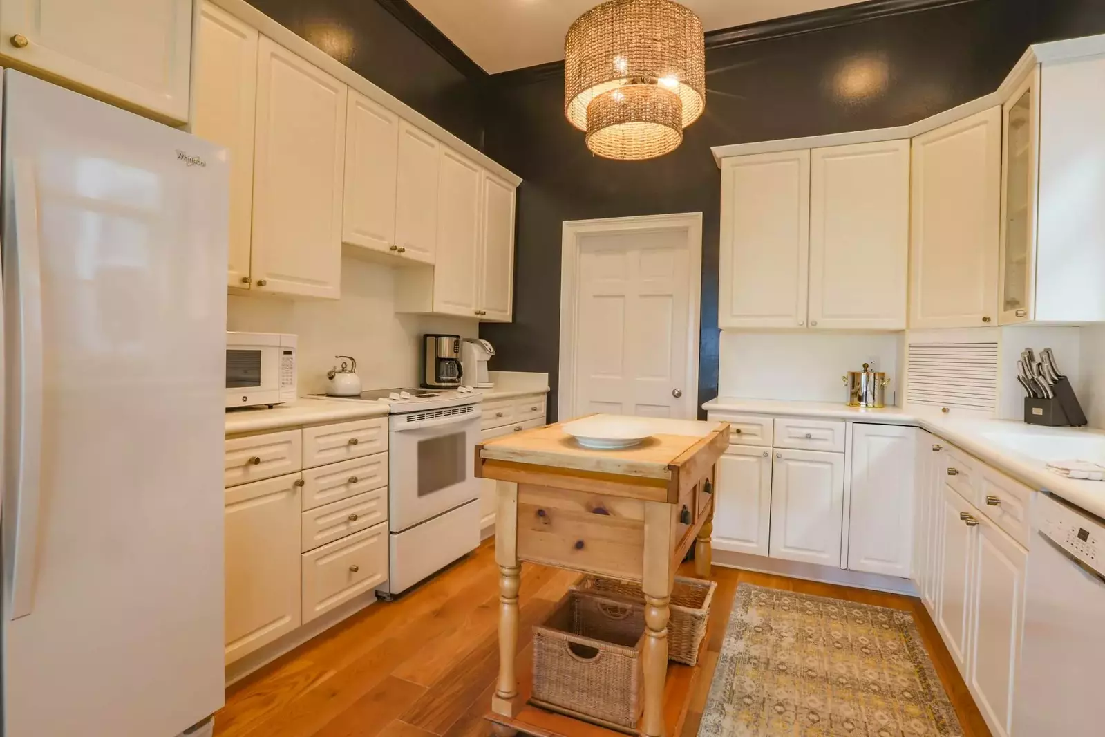 The kitchen features white cabinetry & appliances and plenty of room to prepare your meals.