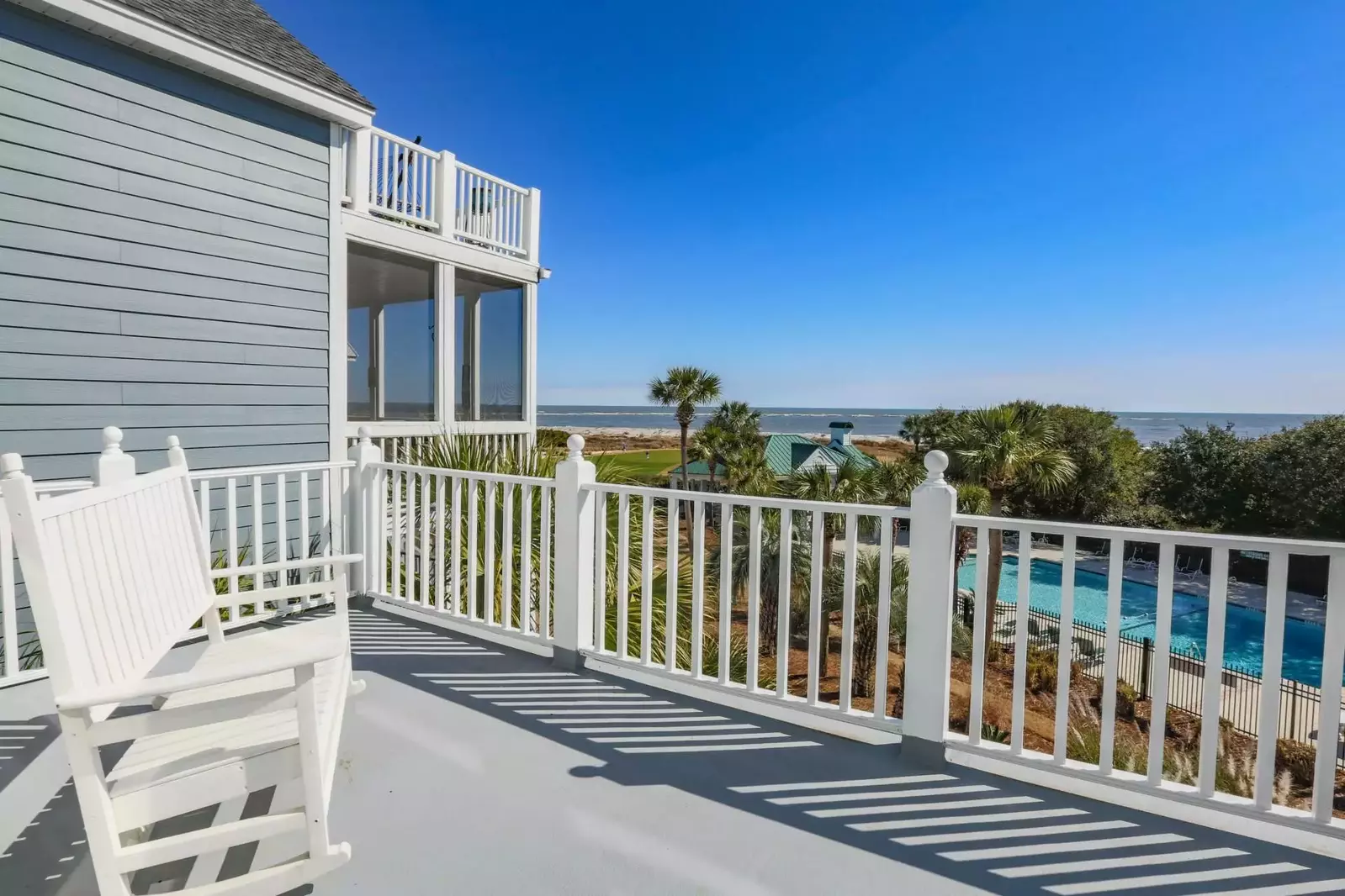 This seating area on the private balcony off the master suite enjoys fabulous views of the ocean & pool.