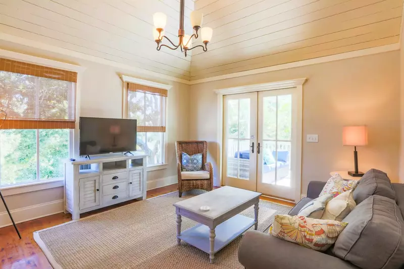 The den features a seating area, smart TV, terrific natural light and access to the covered porch.