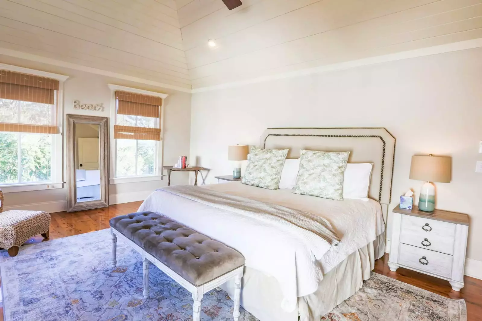 The master bedroom features a king bed, night stands with reading lamps and a seating area.