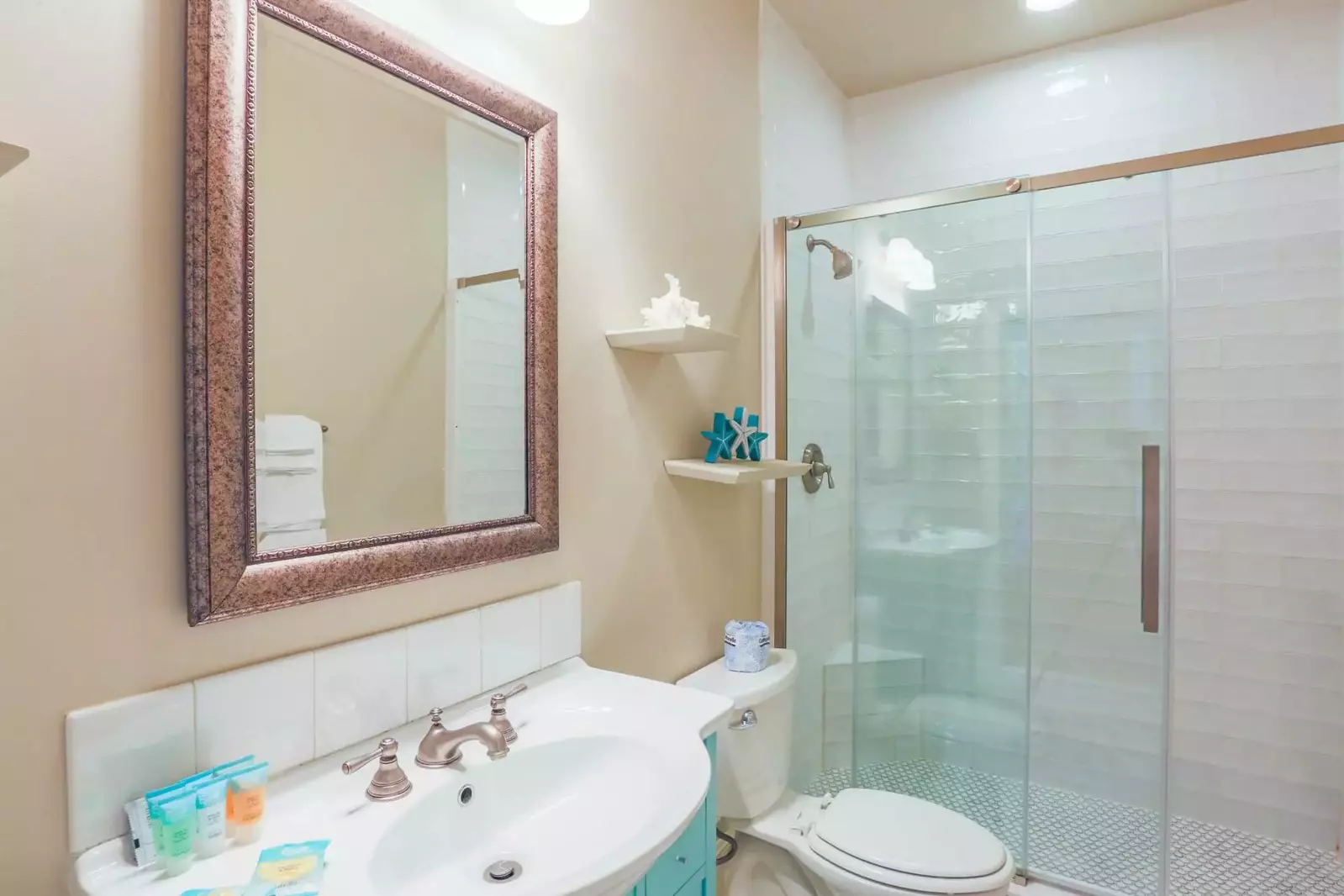 This bathroom, which is accessible from the hallway, features a tiled, walk-in shower and spacious vanity.