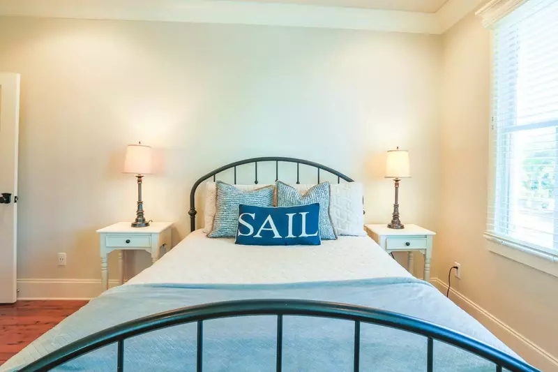 This guest bedroom has a queen bed, night stands with reading lamps and access to the back deck.
