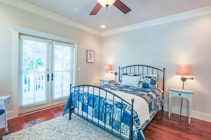 This guest bedroom features a queen bed and access to the back porch.