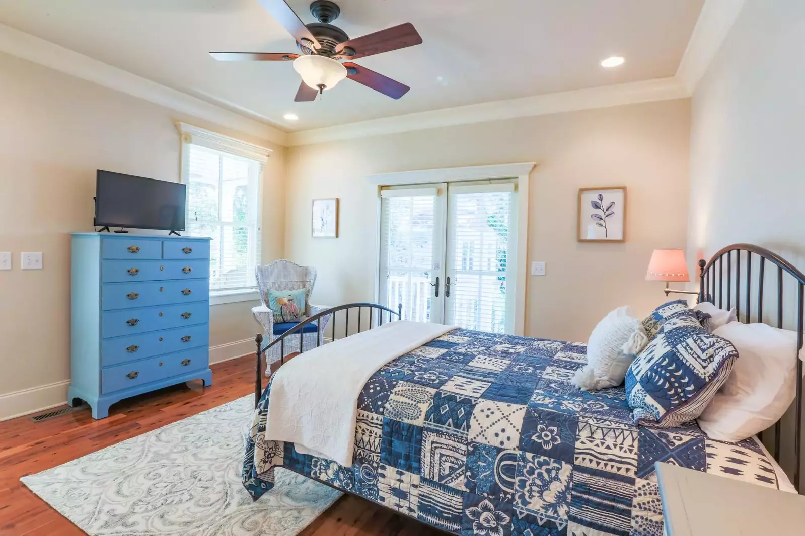 This guest bedroom features a queen bed and access to the back porch.