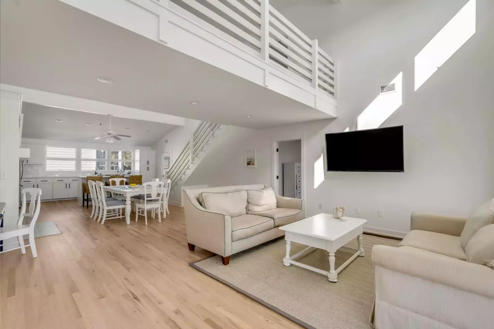 There is a modern, open floor plan layout between the living room, dining area and kitchen.