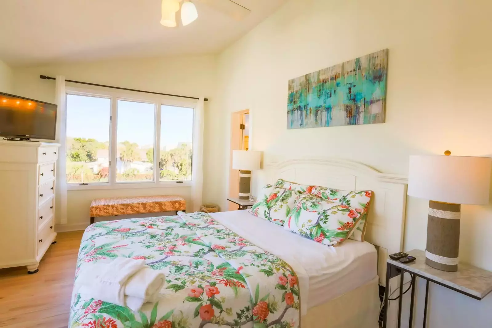The second master suite features a queen bed, night stands with reading lamps and an en suite bathroom.