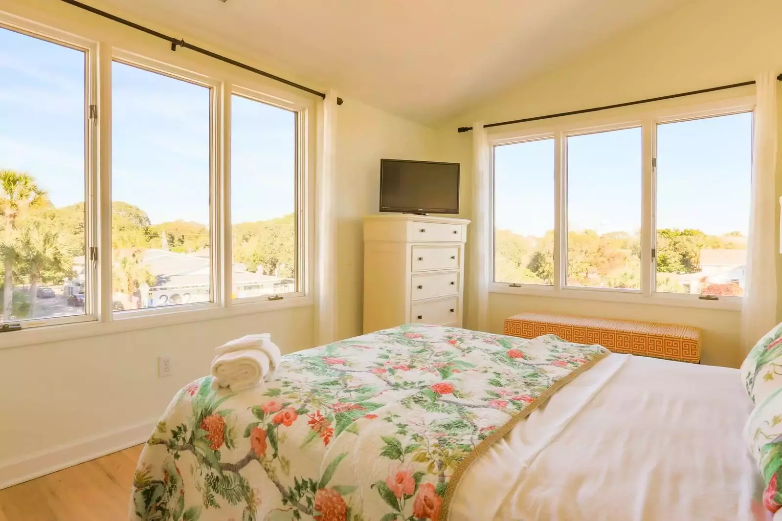 The second master suite features a dresser, smart TV and gorgeous natural light.
