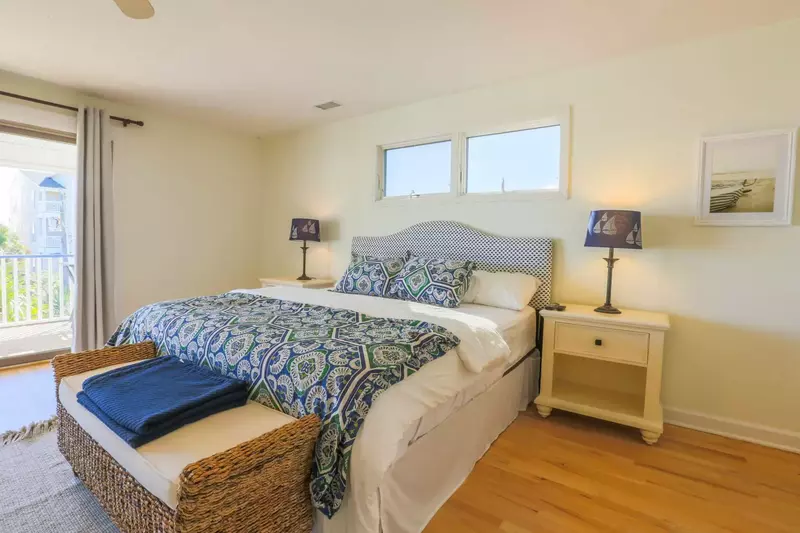This guest bedroom has a king bed, night stands with reading lamps and a bench.
