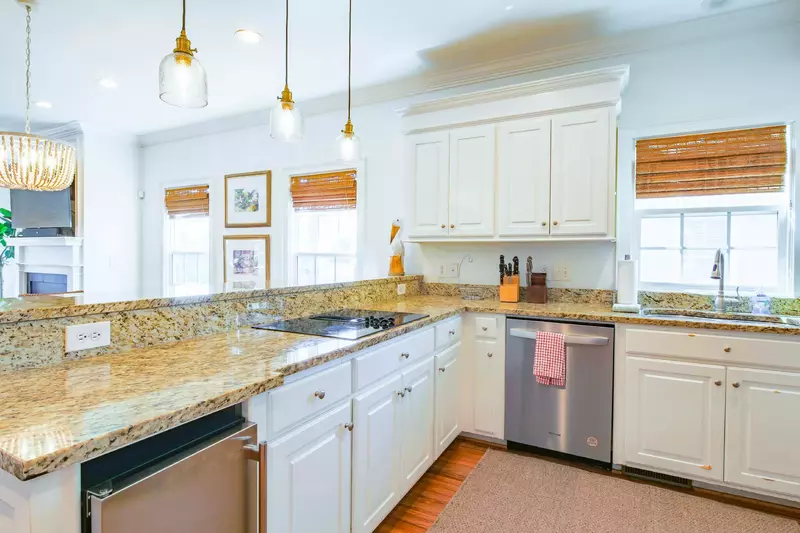 The kitchen features white cabinetry, granite countertops and stainless steel appliances.