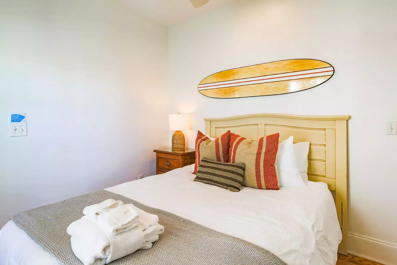 This guest bedroom features a queen bed and night stand with reading lamp.