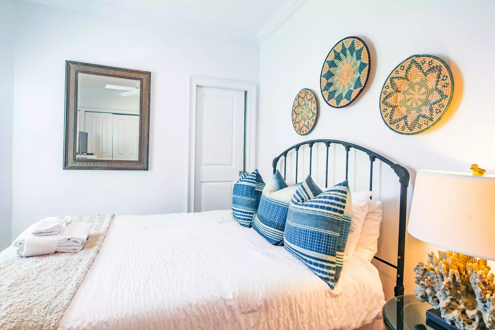 This guest bedroom on the first floor features a queen bed, night stand and reading lamp.