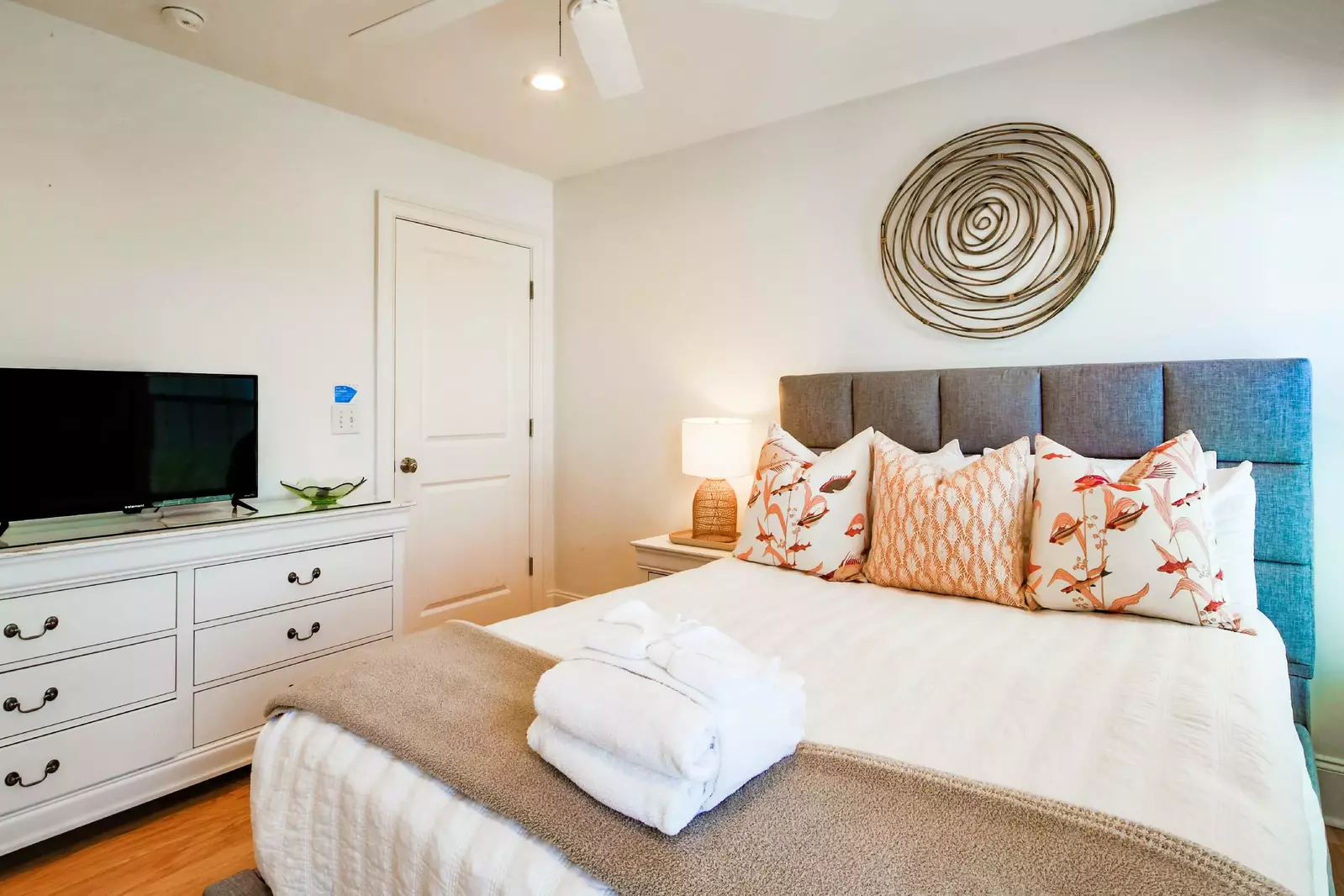 This second floor guest suite features a queen bed, a dresser and a smart TV.