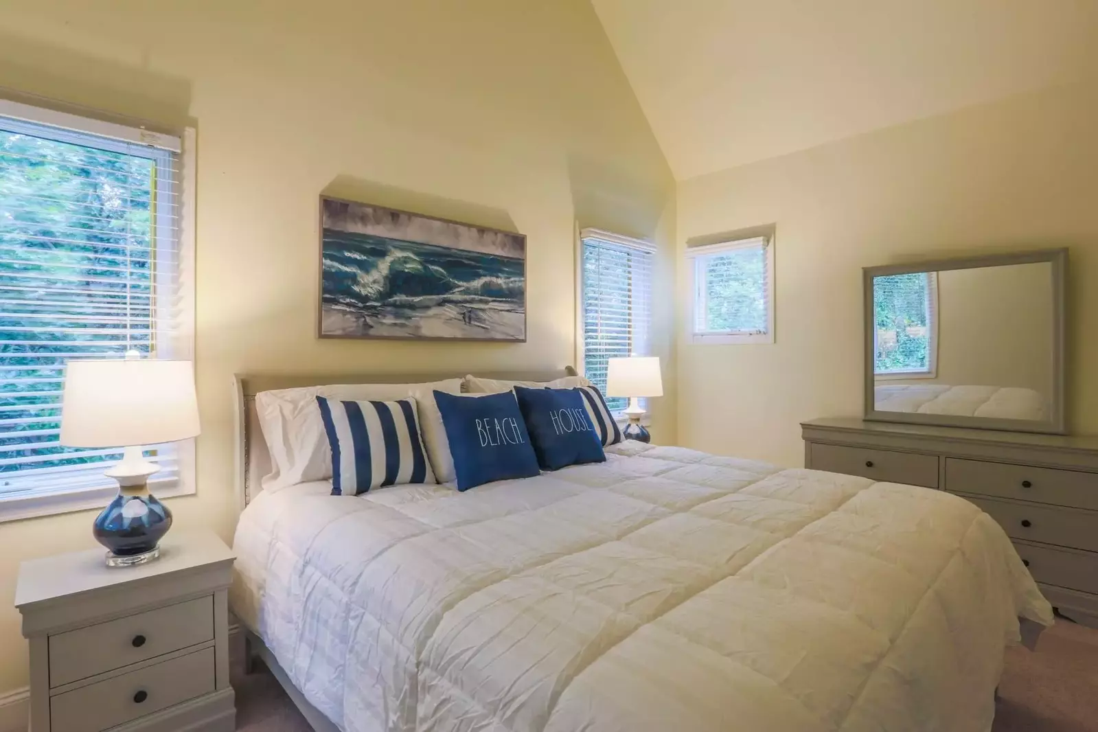 The master bedroom features a king bed, night stands with reading lamps and a dresser.