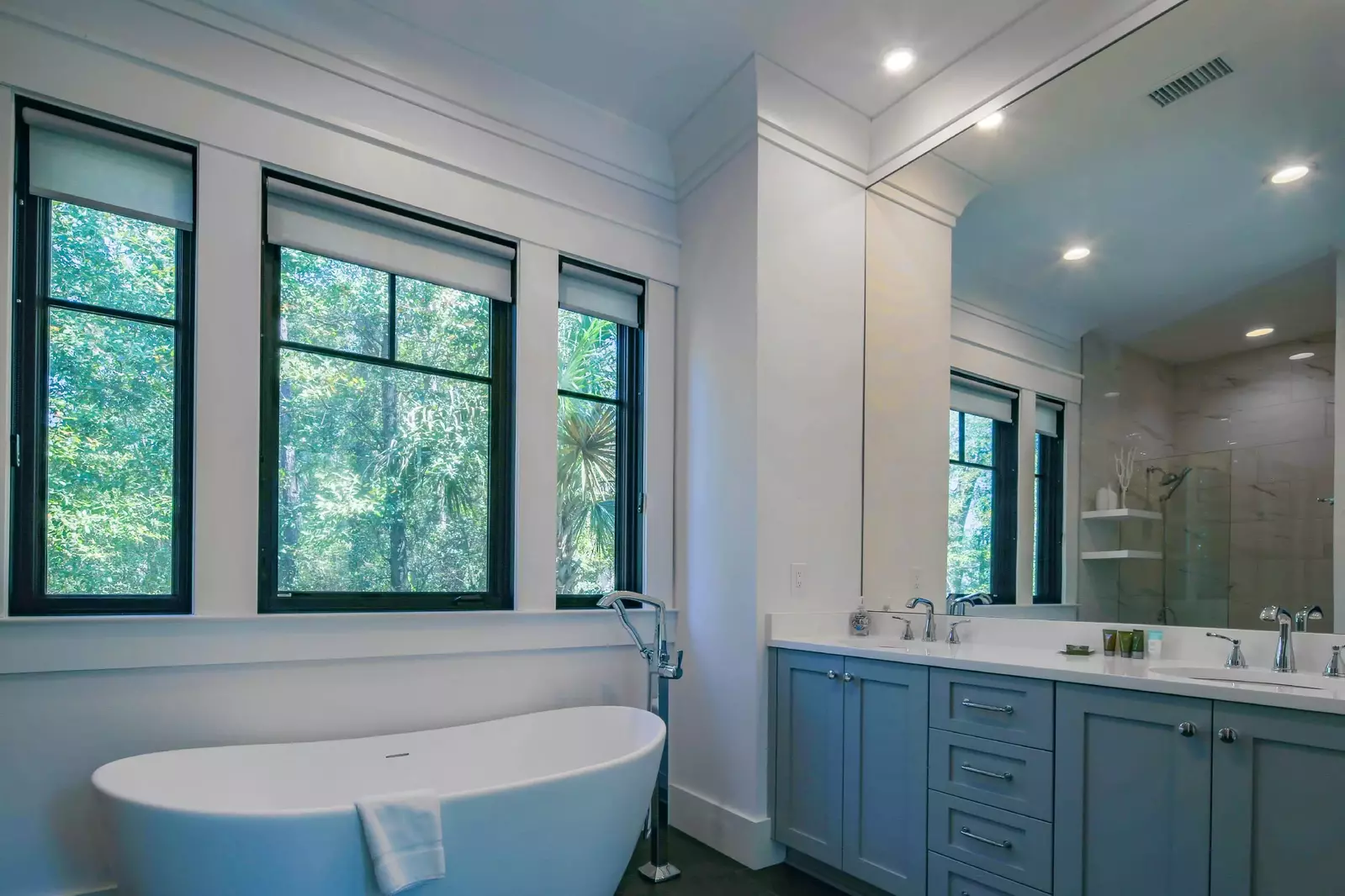 The en suite bathroom for the primary bedroom features a dual sink vanity, tub and walk-in shower.