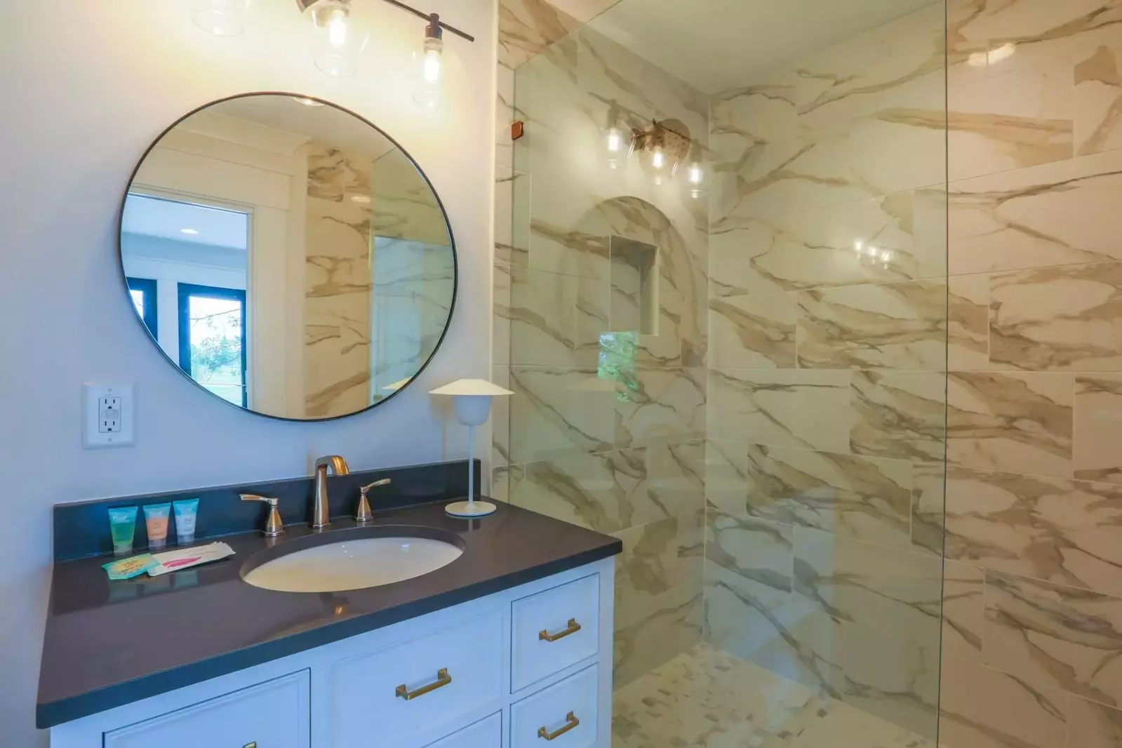 The en suite bathroom has a gorgeously tiled walk-in shower and a spacious vanity.