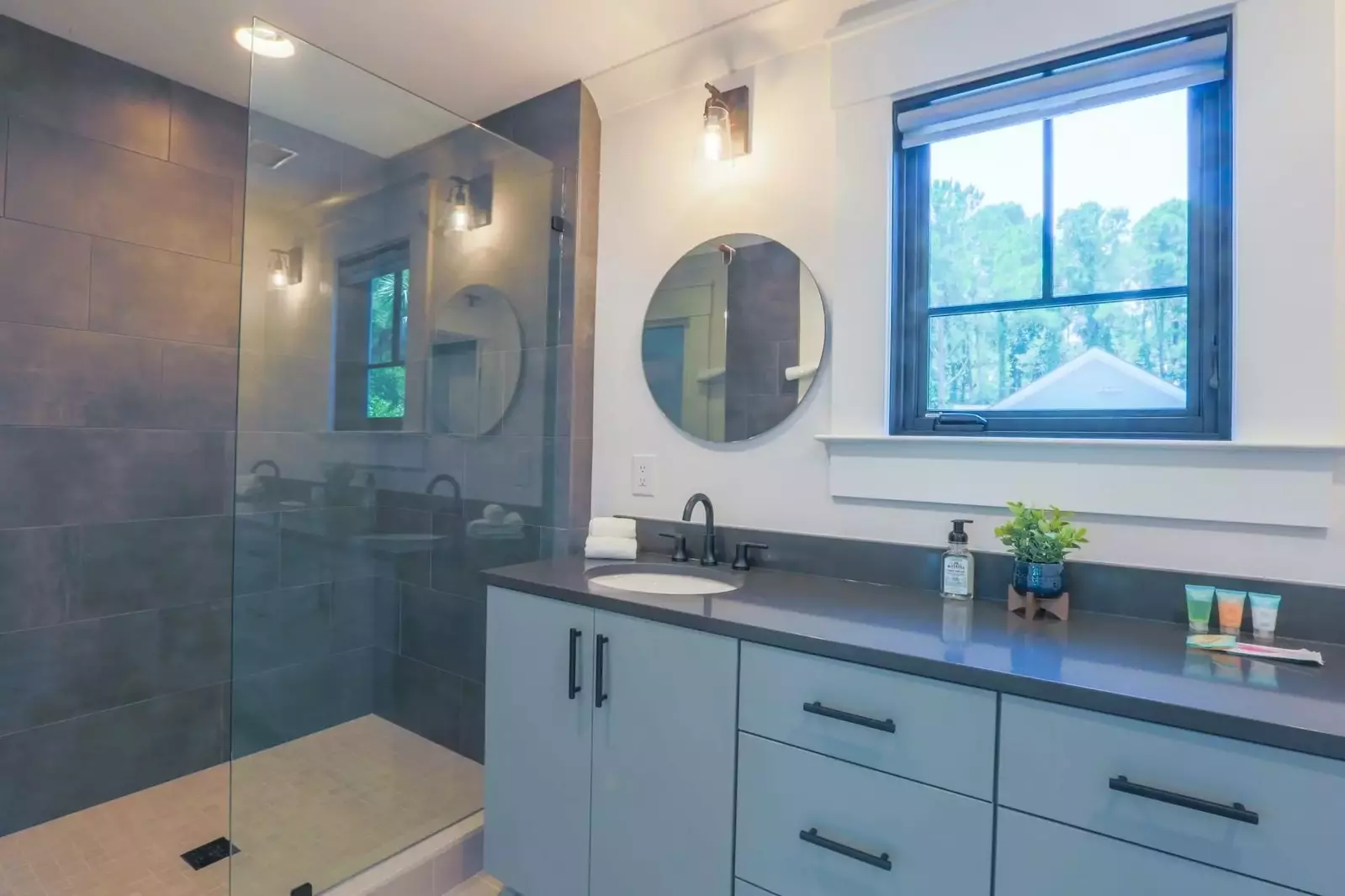 This en suite bathroom has a tiled walk-in shower, large vanity and separate water closet.