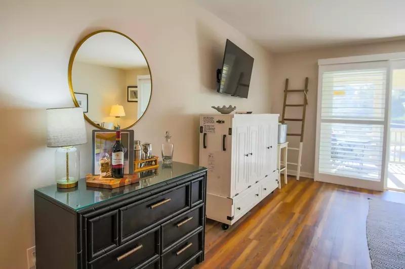 The white cabinets beneath the mounted TV holds a queen sized Murphy bed.