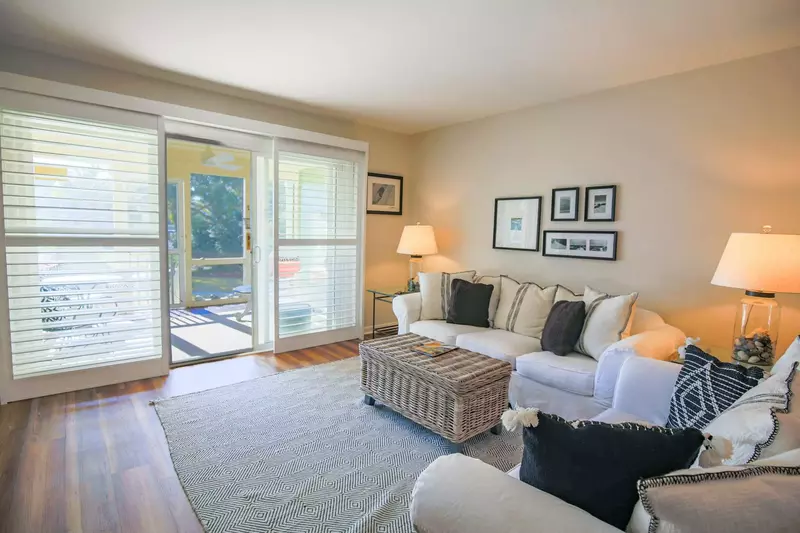 The living room looks out onto the screened porch and community pool.