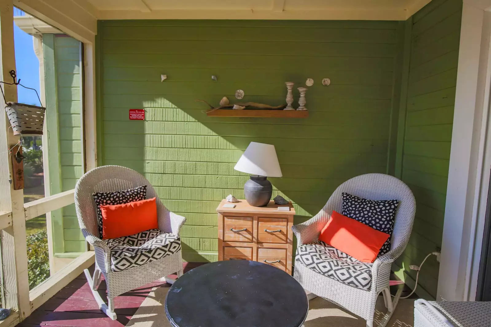 The screened porch receives lovely natural light and refreshing ocean breezes.