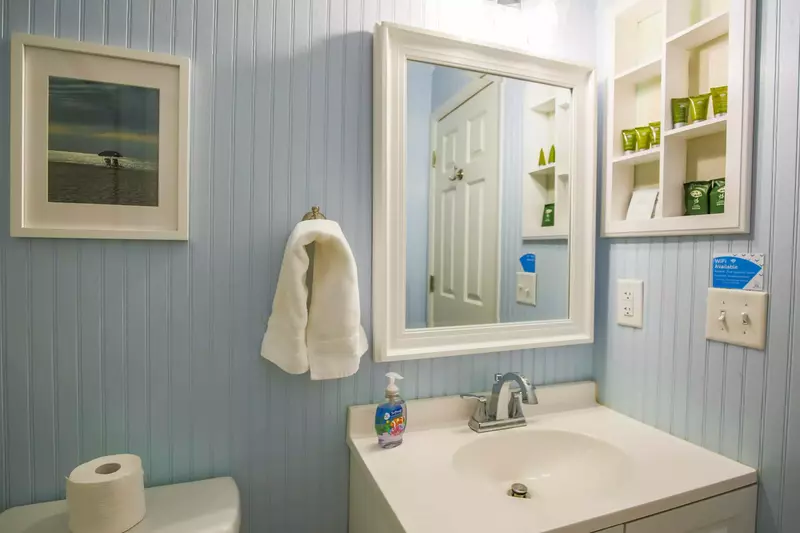 The bathroom features a vanity and wall shelving to store your personal items.