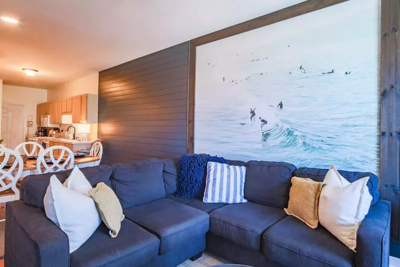 The living room features a spacious sectional and shiplap walls.