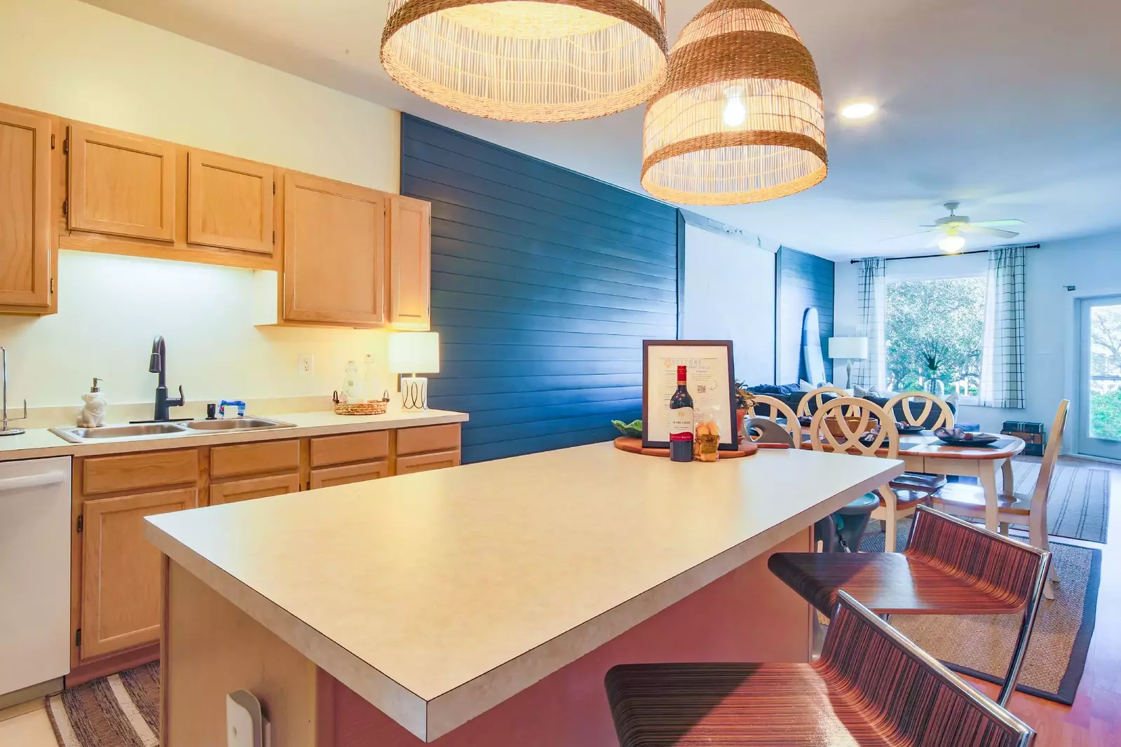 The kitchen features a central island with two stools.