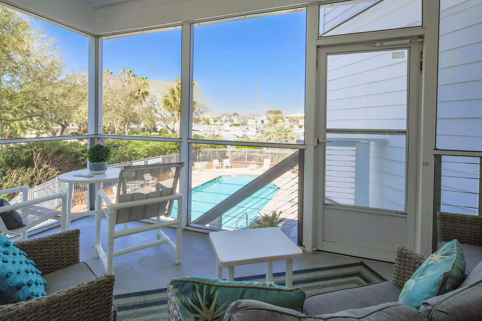 The screened door leads to the exterior staircase that enables you to access the community pool.