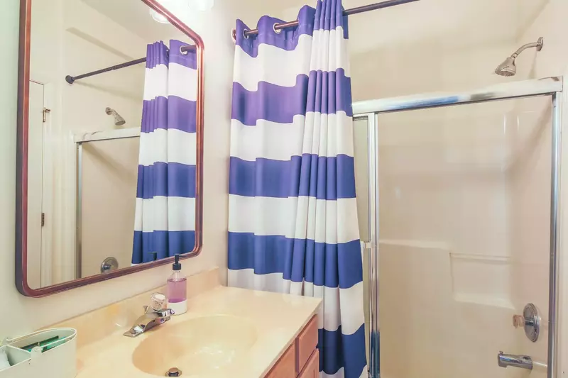 This bathroom features a spacious vanity and a shower/tub combo.
