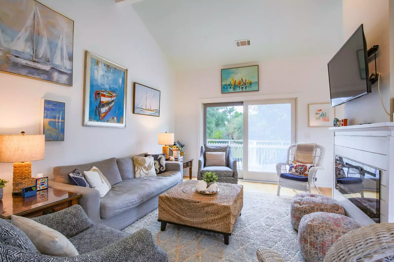 The living room features vaulted ceilings, spacious seating, a wall-mounted streaming TV and access to the back porch.