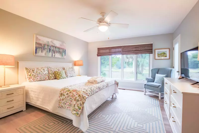 The master suite, which is located on the first floor, features a king bed and night stands with reading lamps.
