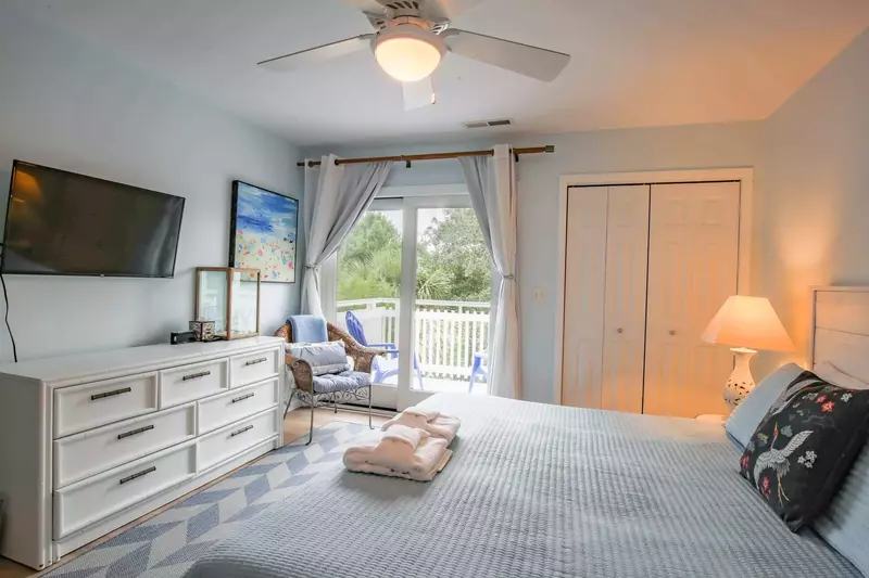 This guest bedroom also has a dresser, streaming TV and sliding door access to a private balcony.