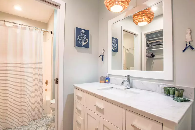 The nautical bedroom has an en suite bathroom with spacious vanity and a shower/tub combo.