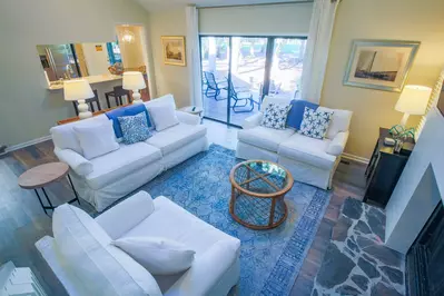 The living room features vaulted ceilings, a comfortable seating area and access to the back porch.