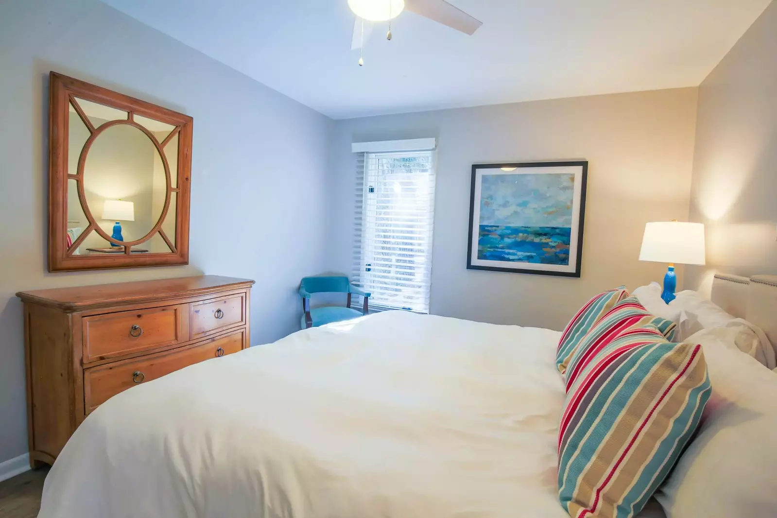The bedroom also has a dresser, ceiling fan, seating chair and an en suite bathroom.