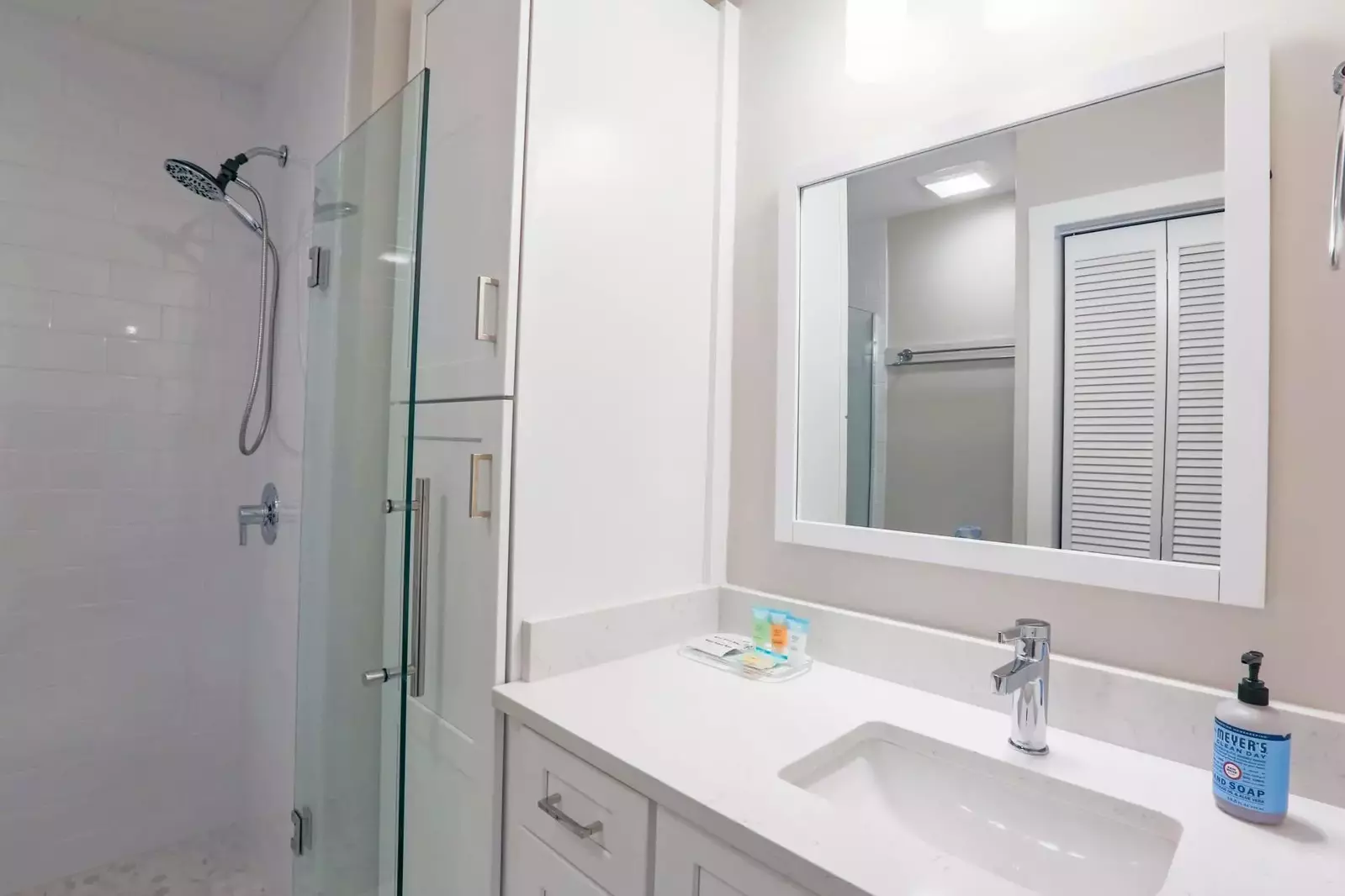 This newly added bathroom features white cabinetry and a tiled, walk-in shower.