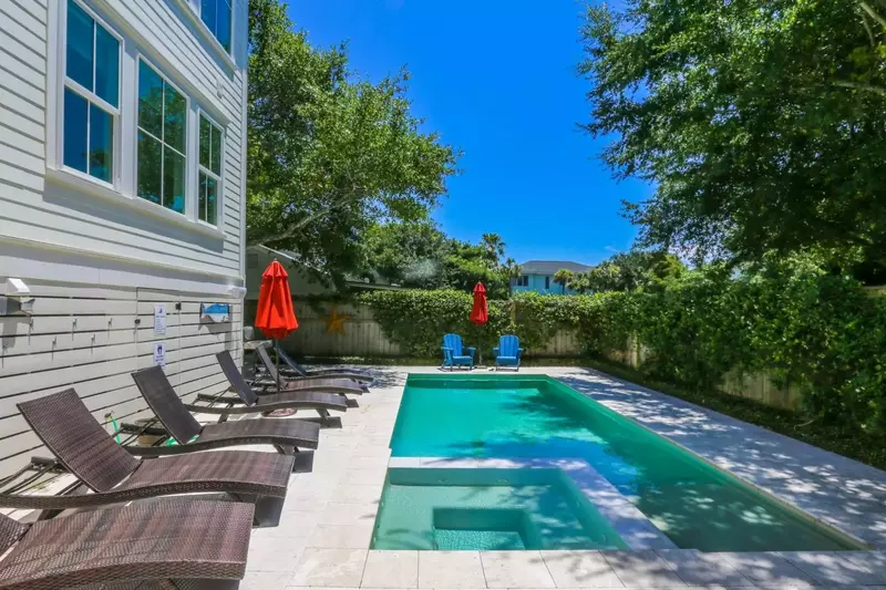 The backyard features a sundeck that surrounds a custom in-ground pool and hot tub.
