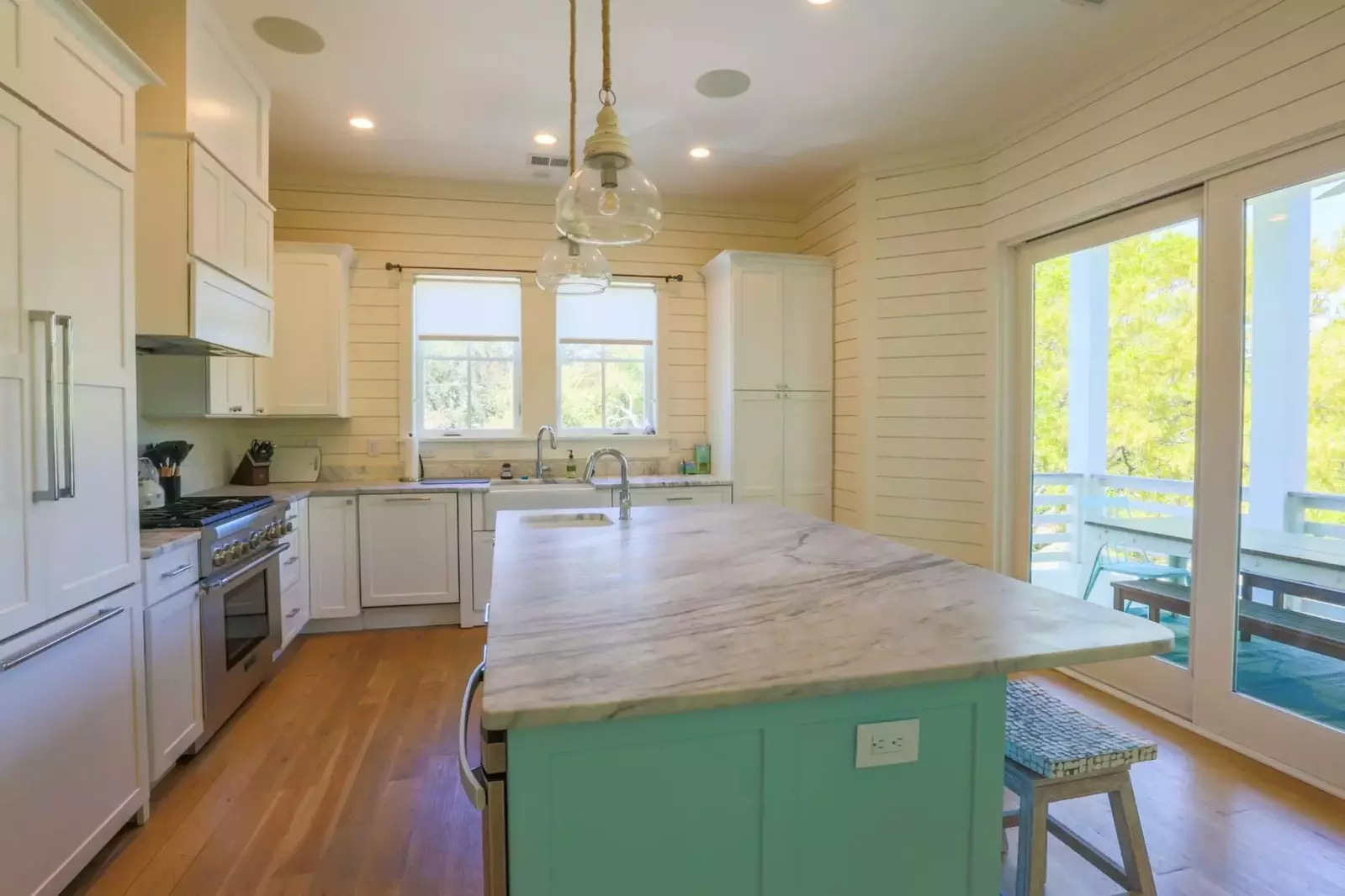 The kitchen has a large center island, white cabinets and beautiful stone counters.