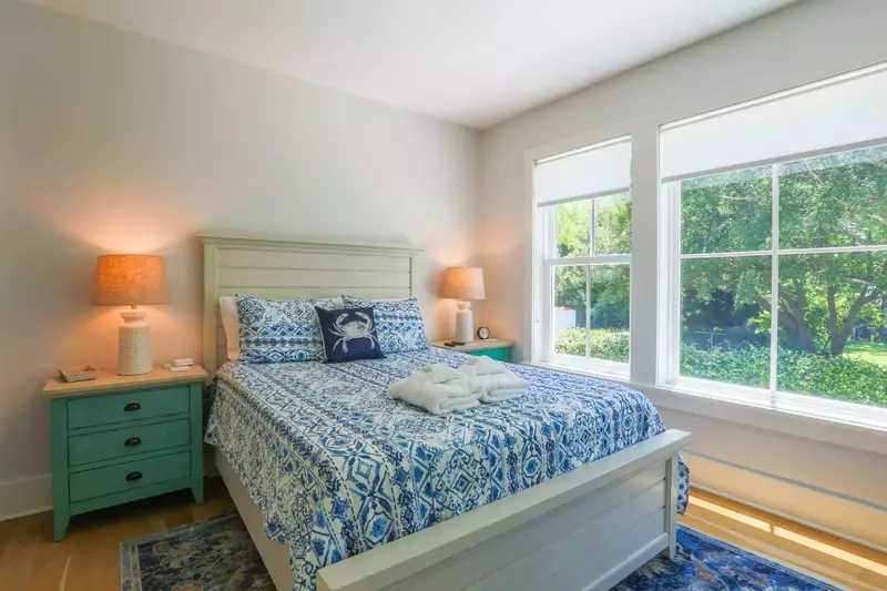 This bedroom has a queen bed, night stands with reading lamps and an en suite bathroom.