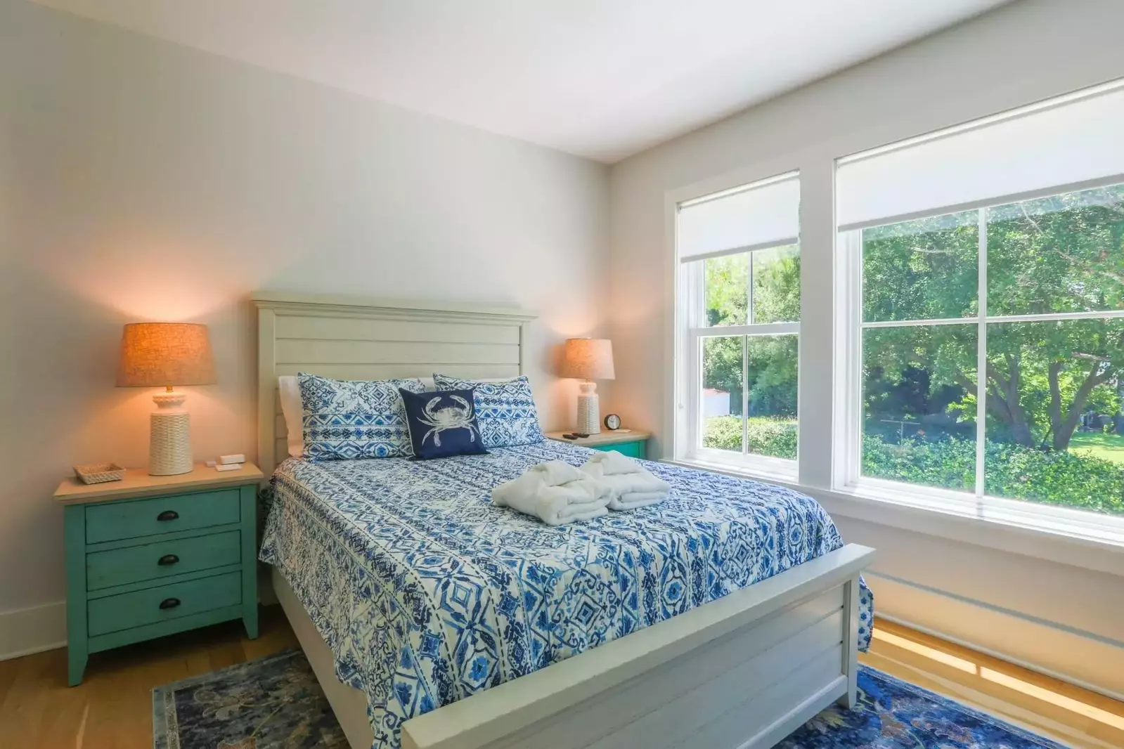 This bedroom has a queen bed, night stands with reading lamps and an en suite bathroom.