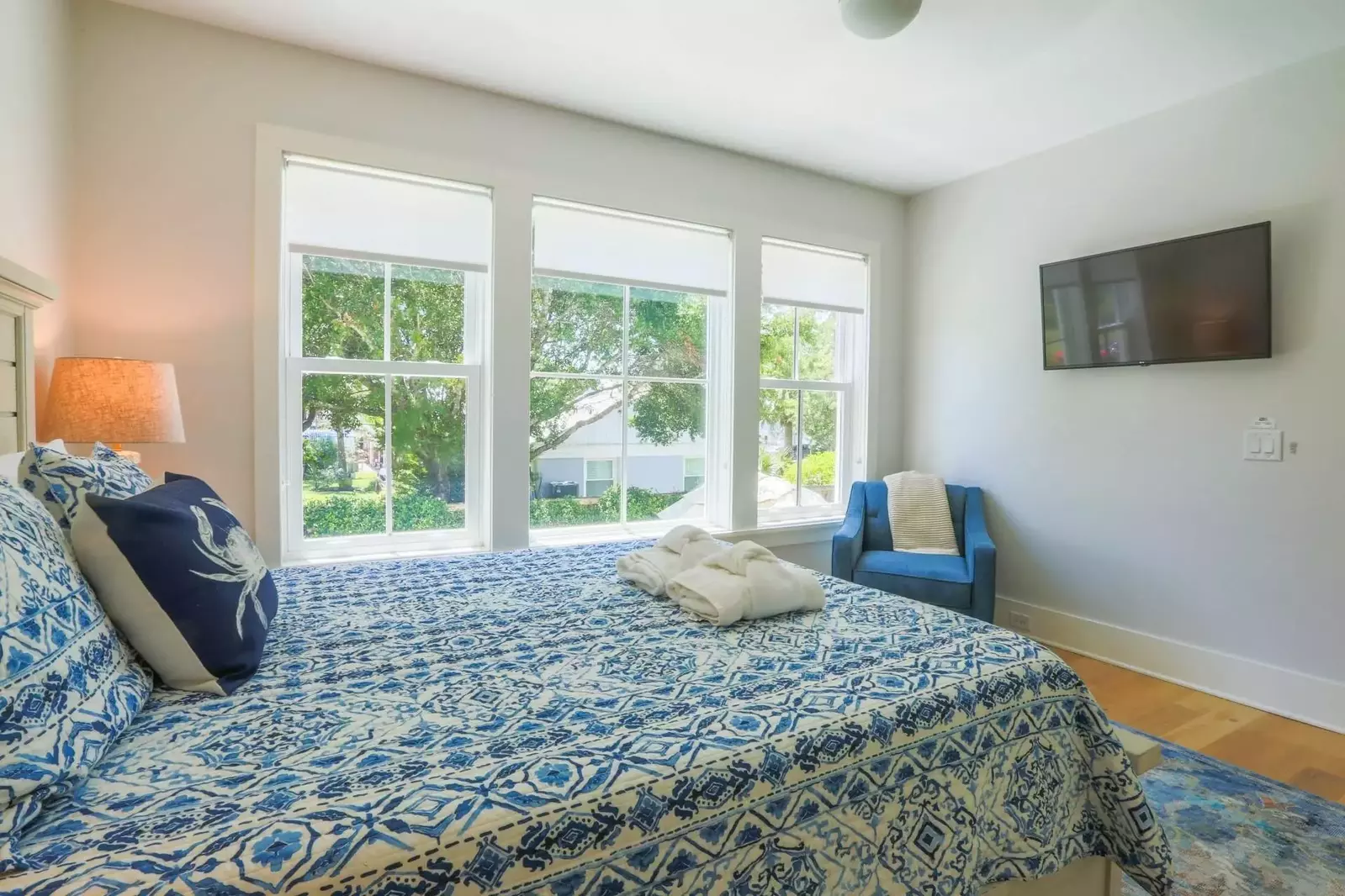 The bedroom has a mounted smart TV and wonderful natural light.