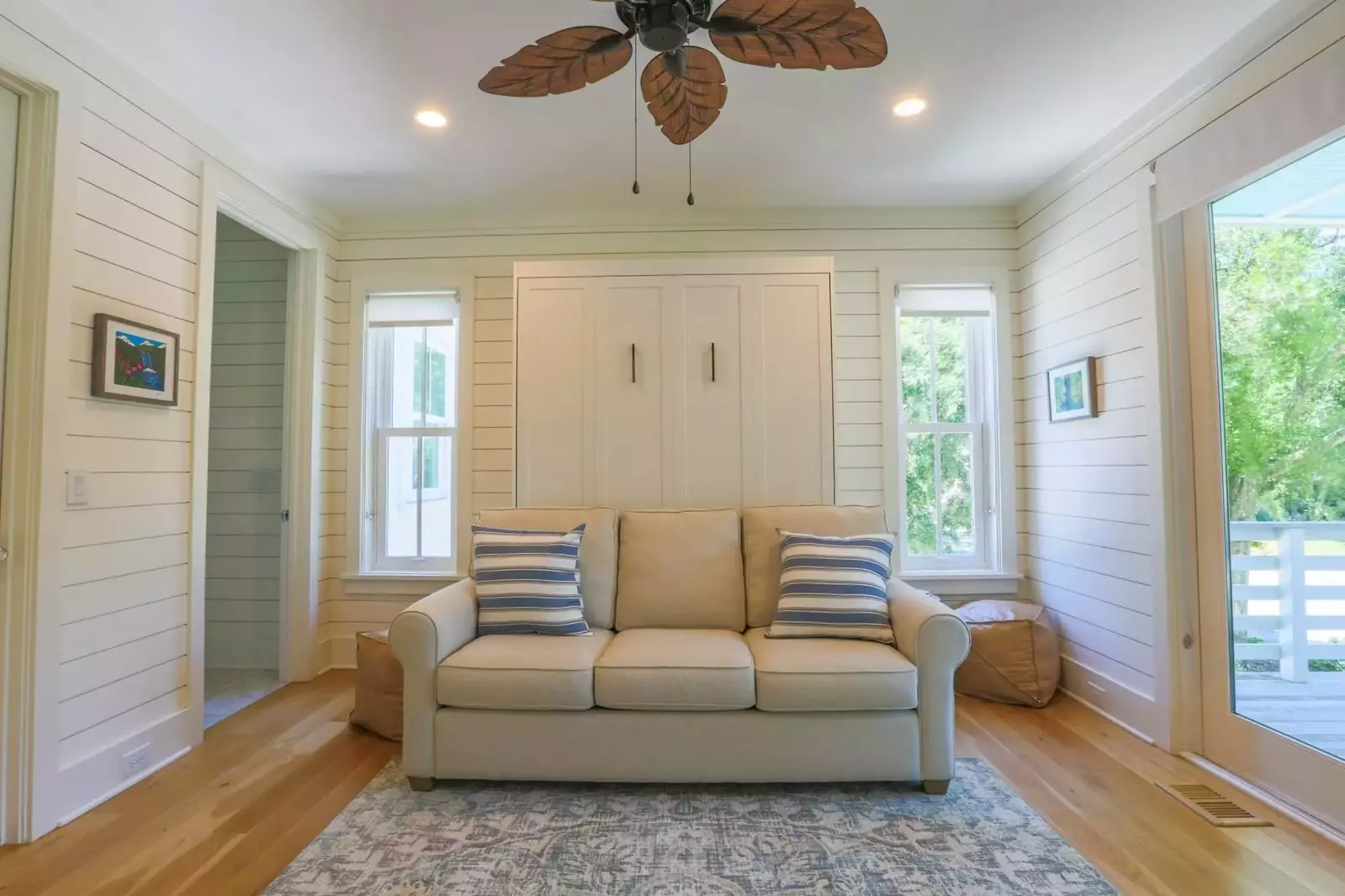 The first floor master suite features a queen Murphy bed, ceiling fan and access to a covered balcony.