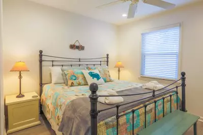 The master bedroom features a king bed and nightstands with reading lamps.