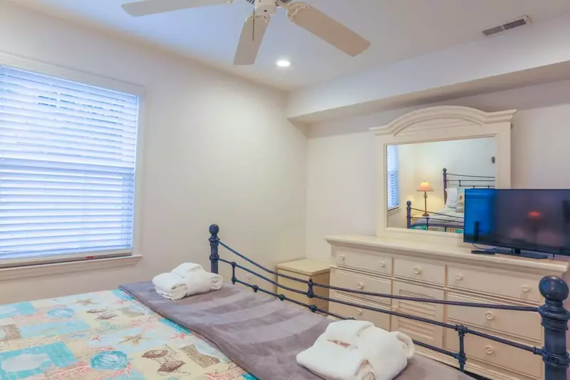 The master bedroom also has a dresser, smart TV and ceiling fan.