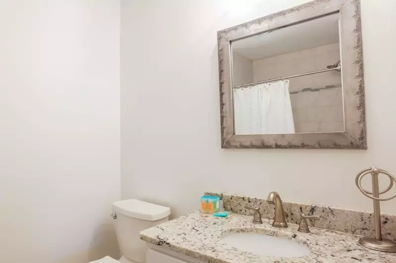 The ground floor bathroom features a spacious vanity with a granite countertop.