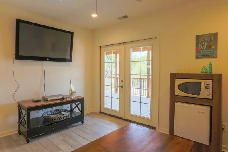 There is a mounted smart TV, small refrigerator and microwave in the second floor living room.