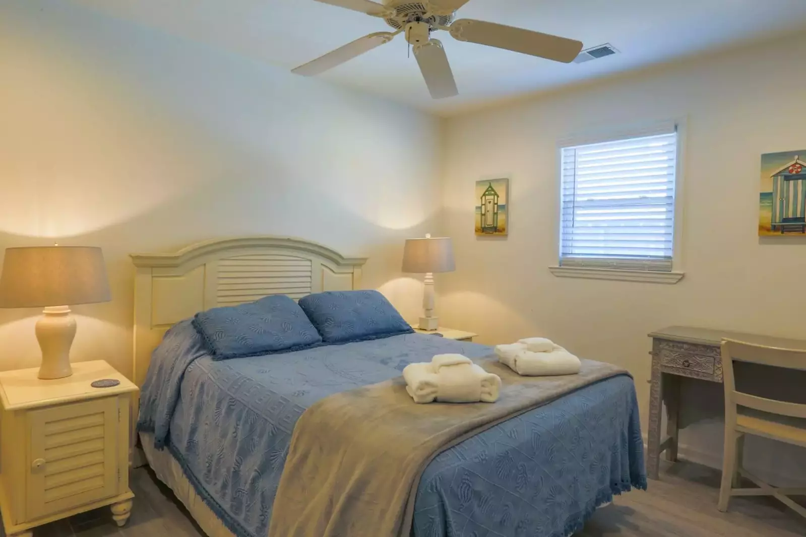 This guest bedroom features a full bed and nightstands with reading lamps.